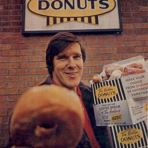 Tim Horton holding Tim Horton’s donuts in the 1970s