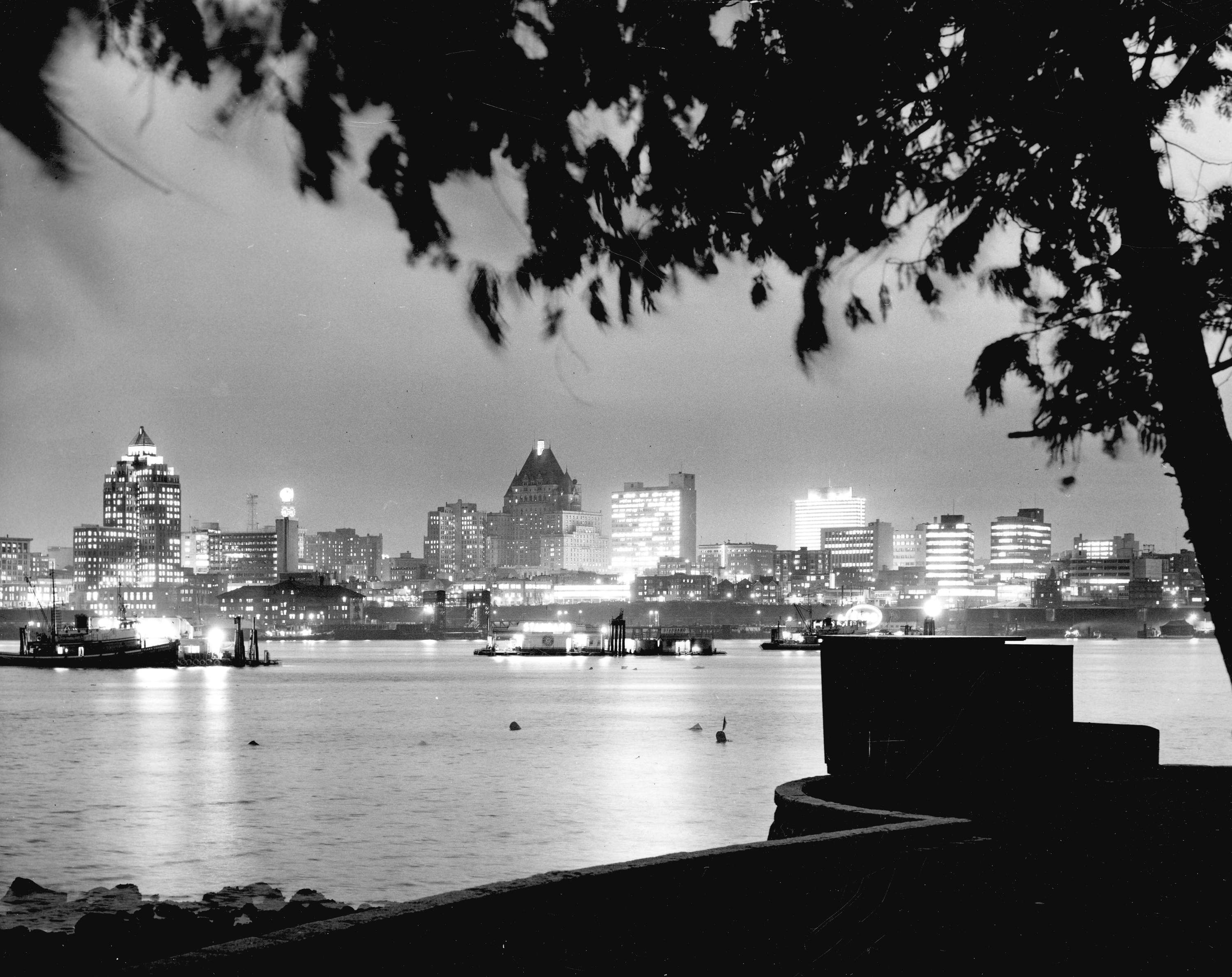 Vancouver's skyline by night as seen from Stanley Park across Burrard Inlet in 1961.  credit: Vancouver Archives
